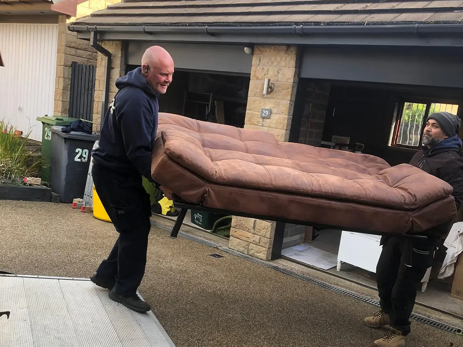 Two-person sofa carry during a residential move