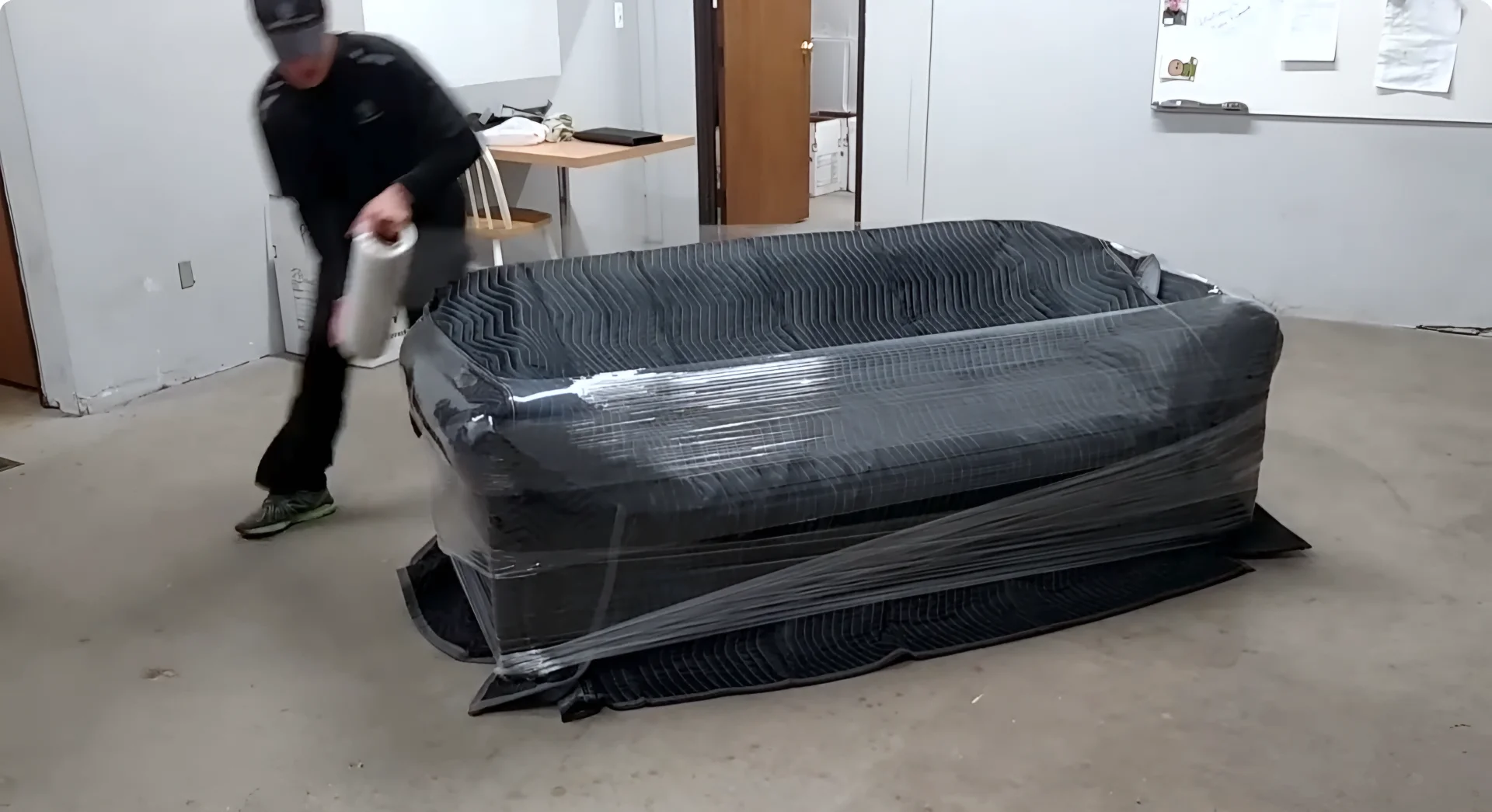 Furniture movers preparing a piece for transport